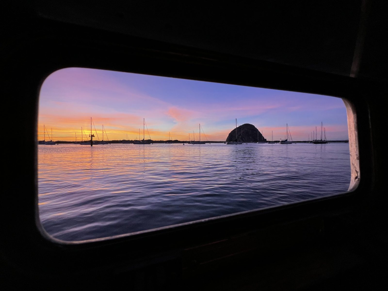 A sunset framed through a cabin porthole